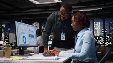 İşletme faaliyetleri için yeni bir strateji geliştirmeden önce, ofisteki masaüstü bilgisayarı ile ilgili veri içgörülerini analiz eden siyah iş arkadaşları ekibi, analiz tahminine danışıyor.