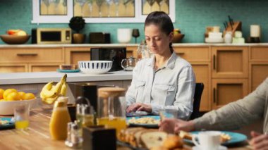 Annesinin kahvaltıda kızını görmezden gelip işine odaklanması laptopta bilgi yazması ve endişeli görünmesi. Kariyeri ve ergen bir kızı olan mesafeli çalışan bir anne. Kamera B.