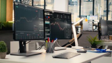 Tescilli firma ofisinde borsa grafiklerini gösteren bilgisayar ekranları. Borsa analizi ve strateji planlaması için kullanılan komisyon işi çalışma masası kurulumu