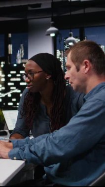 Ofisteki dikey video mühendisliği ekibi bilgisayar kullanarak yapay zeka sistemlerindeki hataları düzeltmeye çalışıyor. Ekip çalışanı meslektaşlar, PC, kamera A kullanılarak teknolojik başlangıç işyerindeki sinirsel ağ hatalarını görüntüler.