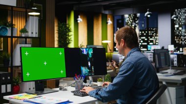 Pazarlama analistinin yanında çift monitörlerde akıllı telefon video görüntülerini düzenleyen, video oluşturma için profesyonel araçlar uygulayan bir model. Hedefleme algoritması bağlantı ve ulaşım için yer değiştiriyor. Kamera A.