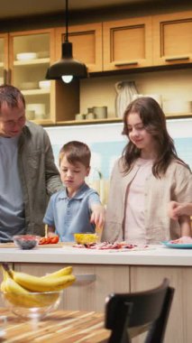 Dikey Video Gülen Aile, mısır ve malzemelerle birlikte ev yapımı pizza yapıyor. Sıcak hafta sonu aktiviteleri bağ kurmayı, yemek pişirmeyi ve evde lezzetli bir yemeği paylaşmayı sağlar. Kamera.