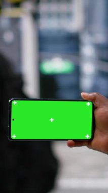 Dikey Video Yatay Yeşil Ekran, çeşitli yayaların kesişiminde, dinamik şehirde, modern kültürde ve metropolün aktif sokak yaşamında siyahi bir kadın tarafından tutuldu.