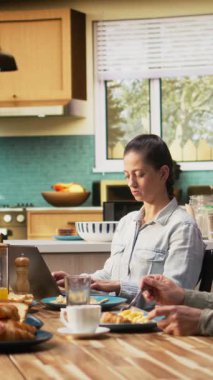 Dikey Videolu Anne dizüstü bilgisayarda uzaktan kumanda yaparken ergen kız, babası, ailesi ve kızıyla mutfakta ev yapımı yemek yerken sohbet ediyor. Hafta sonları bağ kurma zamanı. Kamera A.