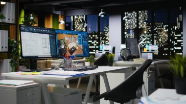 CAD arayüzü olan çağdaş ofis masasında dijital planlar ve mimari projelerin 3D çizimleri sergilenmektedir. Mimarlık ve inşaat profesyonelleri için ideal bir plan..