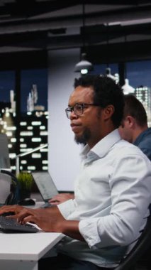 Şirket işyerindeki dikey video yazılım geliştiricisi yapay zeka teknolojisi kalite güvencesi veriyor. IT çalışanı ofiste klavyede yazı yazıyor, programlama ile yapay zeka betiği yazıyor