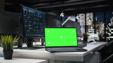 Gece geç saatlerde modern yüksek katlı ofiste yapay zeka algoritmaları geliştirmek için kullanılan yeşil ekran laptop. Boş teknoloji ajansı işyerindeki nöral ağ binasındaki model defter.
