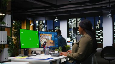 Siyahi kadın grafik tasarımcısı tarafından modern bir düzen, üç boyutlu modelleme programı ve çift ekran monitörlerde krom anahtar yaratmak için kullanılan izole edilmiş model ve CAD yazılımı. Mimari tasarım varlıkları. Kamera A.