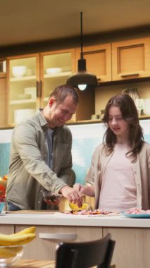 Dikey Video Ebeveynleri genç kızlara mutfakta aile pizzası tarifi yapmayı öğreterek etkin bir şekilde yemek pişirmeyi öğrenmek için gerekli adımları anlatıyor. Rahat evde ev yapımı pizza yapmak.