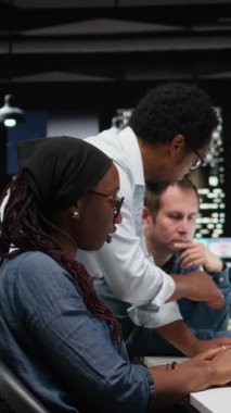 Dikey video mühendisliği ekibi ofiste beyin fırtınası yapıyor, bilgisayarda kod yazıyor, görevleri otomatikleştirmek için makine öğrenme modelleri geliştiriyor. Başlangıçta iş arkadaşları PC üzerinde programlama dili betikleri yazarlar