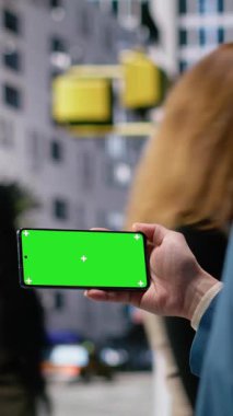 Farklı yaş gruplarının kesiştiği şehrin yakınlarındaki akıllı telefondan izole edilmiş dikey video ekranı, çok kültürlü hareketleri, günlük işe gidiş gelişleri ve modern sokak yaşamının akışını yansıtıyor. Kamera.