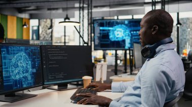 Ofisteki veri bilimci yeni özellikler başlatmak için yazılım geliştiriyor. Başlangıçta bilgisayar programları yazan, kod testi yapan ve kalite güvencesi veren Afro-Amerikalı bir adam. Kamera A