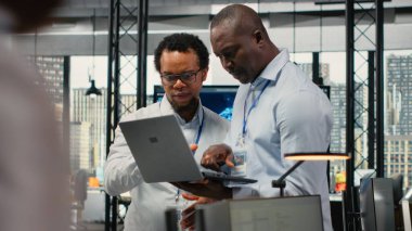 Ofisteki teknisyenler yeni özellikler başlatmak için yazılım geliştiriyorlar. Başlangıçta bilgisayar programları yazan, kod testi ve kalite güvencesi yapan iş arkadaşları, kamera B