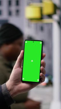 Şehir merkezindeki işlek bir cadde boyunca yürüyen erkek yayanın bulunduğu dikey video yeşil ekran, toplum kültürünü ve metropoliten sokak hayatının durmaksızın hareketini gösteriyor. Kamera B.