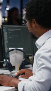 Ofisteki dikey video mühendisi kod yazarken kritik hata uyarısı alıyor. Silikon Vadisi 'ndeki Afrikalı Amerikalı işçiler yazılım arızalarını gidermek ve sistemi çözmek için bilgisayar kullanıyor.