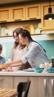 Dikey Video Ailesi mutfakta pizza gününün tadını çıkarıyor ve ev yapımı pizza hazırlıyor. Ebeveynler ve çocuklar lezzetli bir yemekle birlikte kahkaha ve kaliteli vakit geçiriyorlar. Kamera A.