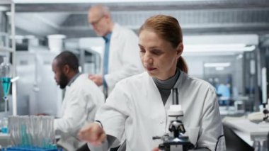 Hematoloji uzmanı. Kırmızı kan hücresi anormallikleri için kan örneklerini analiz ediyor. Sanguine sıvısı şişeleri üzerinde araştırma yapan teknisyen anemi tipleri, kamera B