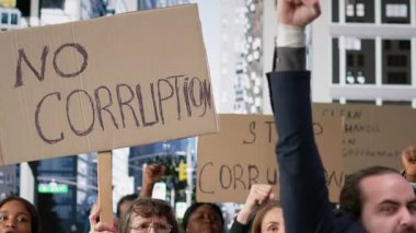 Protestocular, demokrasi ve yolsuzlukla mücadele amaçlı kızgın uyarı mesajları içeren karton afişler ve afişler taşıyan yozlaşmış hükümet ve skandallara karşı bir araya geldiler. Kamera B.