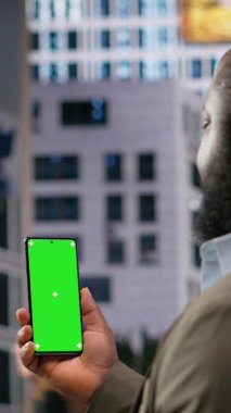 Farklı yaşlarda, metropolün çok kültürlü akışına sahip bir grup insanın etrafında dolaşan Afro-Amerikan bir adamla dikey video yeşil ekran. Gerçekçi hareket ve günlük kültür