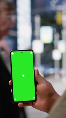 Şehir merkezindeki çok ırklı yayaların şehir içi hareketi yakınlarındaki siyahi bir kadının telefonundaki dikey video yeşil ekran şehir yaşamını, çeşitliliğini ve günlük gerçekçi rutinini kaydediyor.