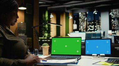 Laptop ve tabletin üzerindeki krom anahtar siyah genel müdürün yanında gece vakti bütçe tahminleri ya da finansal projeksiyonlar yapıyor. İş kadını, cihazlarla önemli görevleri çözüyor. Kamera A.