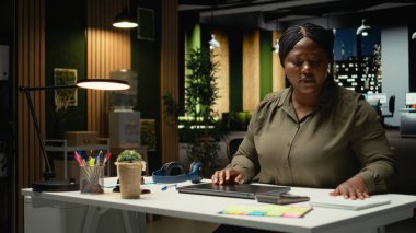 Siyahi iş kadını ofis iş yerindeki bilgisayarını kapatıp gece yarısından sonra işini bitirip evine gidiyor. Fazla mesai yaptıktan sonra iş istasyonunu terk etmek. Kamera A.