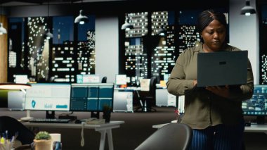 Siyah uzman e-postaları okuyor ve çok uluslu bir şirkete ait bilgileri belgeliyor, karanlık bir ofiste saatler sonra çalışıyor. Girişim hedefleri ve gelişimi üzerine odaklanır. Kamera B.