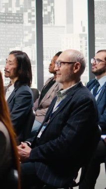 İş adamları ve iş arkadaşları tartışma ve girişimcilik konularına girerken, Dikey Video İzleyicileri el çırpıyor ve sahnede hoparlörleri alkışlıyor. Şirket işi tartışması. Kamera A.