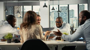 Muhtelif iş arkadaşları ofiste danışmanlık ve rapor paylaşımında bulundu. Profesyonel ekip, iş stratejisi ve performans hedeflerini geliştirmek için görsel verileri ve belgeleri gözden geçiriyor.