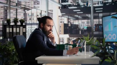 CEO tablet ve dizüstü bilgisayardaki şirket veri raporlarını analiz ediyor ve değerlendiriyor, liderlik ve geliştirme için bilgi grafikleri ve KPI 'leri inceliyor. İşyeri yönetimi ve yürütme yönetimi.