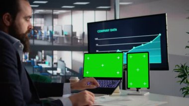 Yeşil ekran, tablet ve dizüstü bilgisayar, dokümanlar hakkında bilgi ve raporlar, karar verme için iş KPI 'leri, verileri kontrol eden işadamı. Finansal yönetim, içgörü ve ölçüler, şirket.