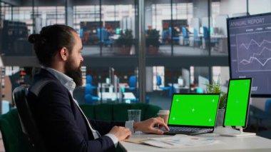 Belgeler ve KPI 'lerle yürütme ofisinde dizüstü bilgisayar ve tablette yeşil ekran, organizasyon içinde karar verme. Evrak işlerinde ölçü analizi, iş bölgesinde ofis hayatı..