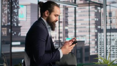 Yetişkin profesyonel cep telefonuyla sosyal medya uygulamalarını tarıyor, ofisteyken akıllı telefondan iletişim kurmak için mesajlaşıyor. Direktör kıyamet, bağımlılık yapıcı alışkanlık ve dikkat dağıtıcı iş.