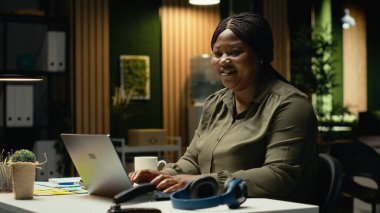 Güncellemeler hazırlayan ve çalışma saatleri dışında özet oluşturan siyahi işçilerin portresi. Aylık planlama, işletme hedeflerine ulaşmak için iş hedefleri ve gündem maddeleri sağlama. Kamera B.