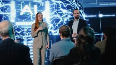 Yapay zeka özellikleri ve veri otomasyonu sunumu sunan iki sunucu, veri bilimi ile yazılım geliştirme. Girişimci ve konuşmacı yatırımcılara ve dinleyicilere hitap eder. Kamera B.