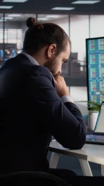 Dikey Video İş Lideri, veri analizi, dizüstü bilgisayar ve tablet cihazları, karar verme için kazanç ölçüleri, strateji planlaması. CEO yönetimi, KPI ve raporlar ekranda, ofiste