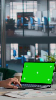 İdari iş ofisindeki bilgisayar ve tablette, belgeler ve KPI 'lerle birlikte dikey video yeşil ekran, organizasyon içinde karar verme mekanizması. Evrak işlerinde ölçü analizi, iş hayatında ofis hayatı.