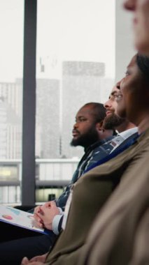 Dikey Video Dünyası konferansında alkışlayan ve alkışlayan dinleyiciler var. Kurumsal tartışmalar sırasında konuşan CEO karışık yaş aralığı seyircisinin katılım ve destek göstermesi üzerine konuşuyor