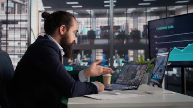 Videodaki kızgın iş adamı ekibinden bıktı, çalışanlarla problem çözmek için online toplantı ve sinir bozucu lider. Rapor ve brifing dizüstü bilgisayarın web kamerası.