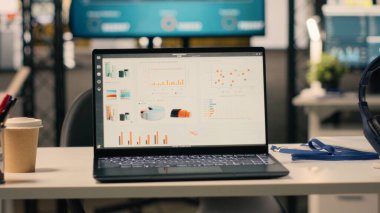Şirket verileri boş yönetici ofisinde, modern mobilya ve ofis malzemeleriyle dekore edilmiş profesyonel çalışma ortamında gösteriliyor. Şık ofisteki hiç kimse, doğal ışık.