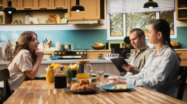 Tablet üzerinde çalışan baba kahvaltı masasında kızını ve ailesini görmezden gelen uzaktan kumandalı işiyle dikkati dağılmış bir adam. Kız ve karısına ilgisiz ebeveyn mesafesi.