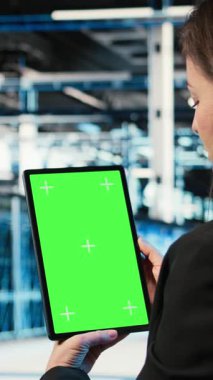 Veri merkezi yönetimi tarafından sunucu yükü dengesini optimize etmek için kullanılan dikey video yeşil ekran tableti. Sistem parametrelerini ayarlamak ve verimliliği arttırmak için model aygıtı kullanan sunucu çiftliği bilişim uzmanı, kamera