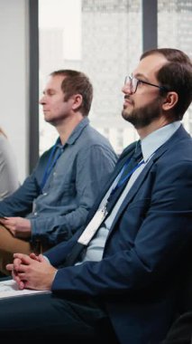 Dikey Video Erkek CEO 'su konferansa katılıyor ve tartışmalara, uluslararası iş forumuna ve sahne sunumuyla zirve toplantısına dikkat ediyor. Konferans salonundaki çeşitli katılımcılar. Kamera A.