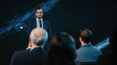 CEO, konferans salonundaki sunum sırasında izleyicilerle iletişim kurar, sahneye çıkar ve panelde tartışmaya başlar. Ağ oluşturma etkinliğine katılanlar. Kamera B.