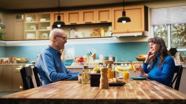 Koca konuşmaya devam ederken kıdemli eş çileden çıkmış ve bitkin görünüyor. Sabah rutin programları, aile içi emeklilik hayatındaki hoşnutsuzluk ve monotonluğu gösteriyor. Bıktım artık. Kamera A.