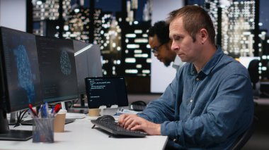 Ofisteki yazılım geliştiricisi yapay zeka hatalarını önlemek için makine öğrenme algoritmalarını analiz ediyor. Yapay zeka tahmin doğruluğunu geliştirmek için kod mantığını inceleyen bir IT uzmanı başlat