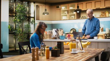 Üst düzey koca, bilgisayarında parlak bir mutfakta web sitelerine kayıyor ve sabah kahvesini yudumlarken sakin bir anın tadını çıkarıyor. Huzurlu bir emeklilik ve mutlu bir yaşam tarzı. Kamera A.