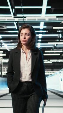 Dikey Veri Merkezi Yöneticisi mavi kablo ağ donanım valflerini inceliyor. Sunucu merkezi satırlarında yürüyen bir sistem yöneticisi AR dijital ikiz veri akışlarına bakıyor, kamera A