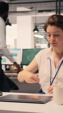 Bir kurumsal ofiste gelir verilerini ve performans ölçümlerini analiz eden dikey video kadın çalışanı. Analiz ve çizelge üzerinde çalışan kadın, kaynak tahsisi ve iş olanaklarını destekliyor