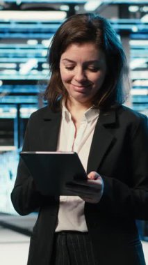 Otomasyon sistemlerini izlemek için AR holografik kaplama kullanan dikey video veri merkezi teknisyeni. Sunucu odası uzmanı, ağ ekipmanı performansını denetlemek için artırılmış gerçeklik projeksiyonunu kullanıyor, kamera